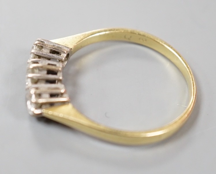 A modern 18ct gold and three stone diamond ring, size O, gross weight 2.5 grams.